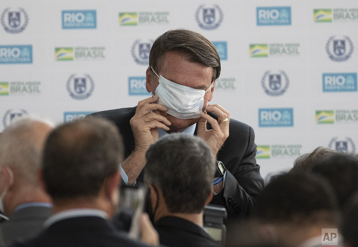  Brazilian President Jair Bolsonaro puts on his mask amid to the COVID-19 pandemic at the inauguration of the new civic-military school General Abreu in Rio de Janeiro, Brazil, Aug. 14, 2020. (AP Photo/Silvia Izquierdo) 