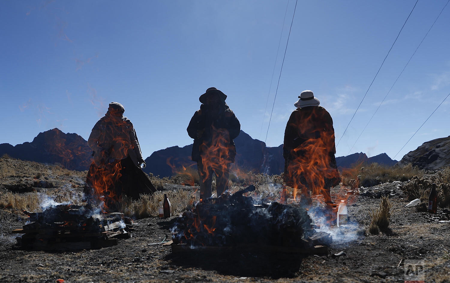  People burn offerings in honor of "Pachamama" or Mother Earth, on La Cumbre, a mountain considered sacred on the outskirts of La Paz, Bolivia, Aug. 1, 2020. (AP Photo/Juan Karita) 