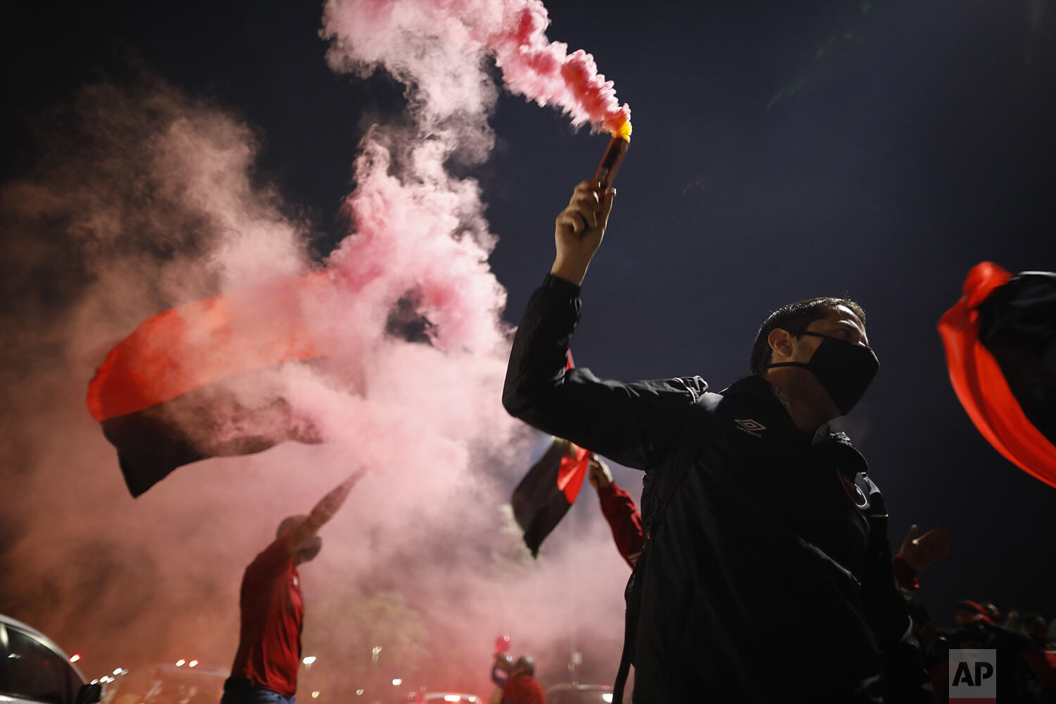  A soccer fan holds a flare during a caravan by Newell's Old Boys club in the hometown of star player Leonel Messi in Rosario, Argentina, Aug. 27, 2020, with the aim of luring him home after his announcement he wants to leave Barcelona F.C. (AP Photo