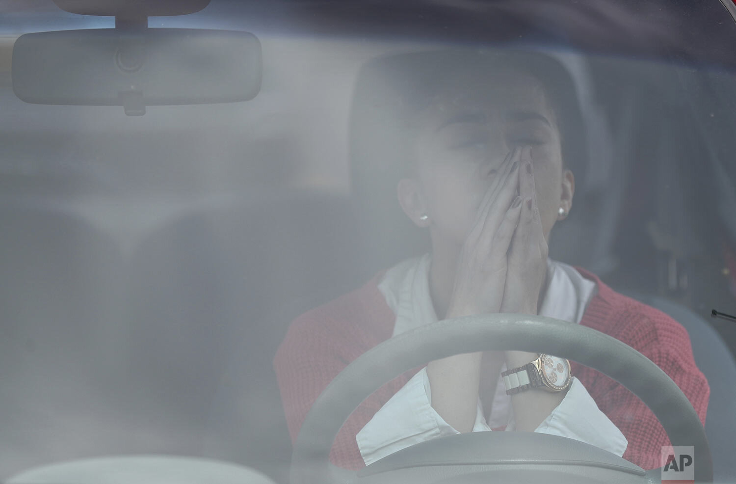  A woman prays inside her car during a Mass held in the parking lot of a former horse racing track in Chia, Colombia, Aug. 30, 2020. (AP Photo/Fernando Vergara) 