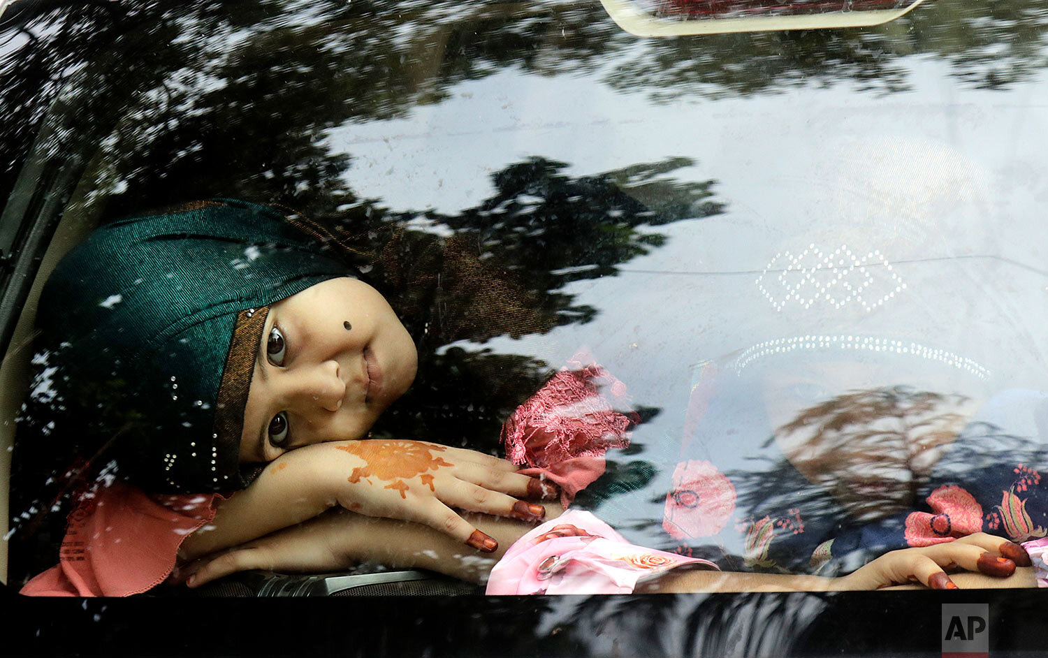  Muslim girls with henna-decorated hands look out from a car on Eid in Mumbai, India, Saturday, Aug. 1, 2020.  (AP Photo/Rajanish Kakade) 
