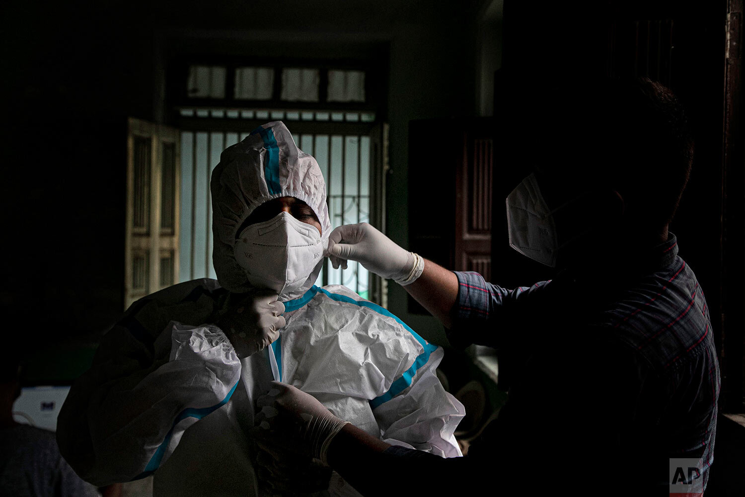  A health worker helps another wear protective gear before proceeding to take nasal swab samples to test for COVID-19 in Gauhati, India, Friday, Aug. 7, 2020.  (AP Photo/Anupam Nath) 