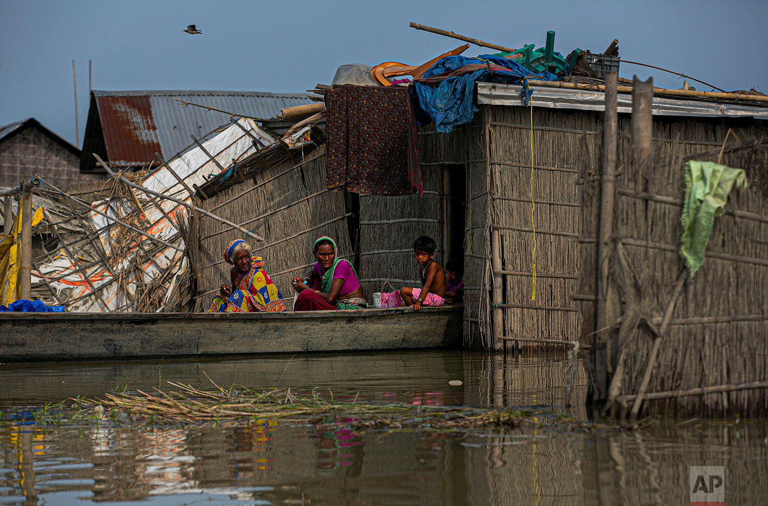  Flood-affected villagers sit on a boat near their submerged houses in Morigaon district of Assam, India, Saturday, Aug. 1, 2020. (AP Photo/Anupam Nath) 