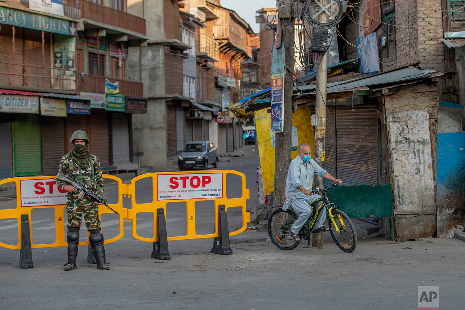  A Kashmiri cycles past a barricade set up as road blockade as a paramilitary soldier stands guard on the first anniversary of India’s decision to revoke the disputed region’s semi-autonomy, in Srinagar, Indian controlled Kashmir, Wednesday, Aug. 5, 