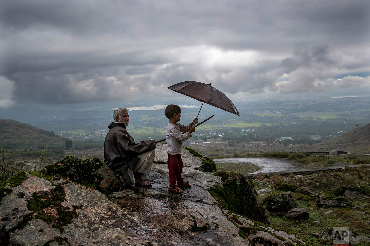  Ali Mohammad, a Kashmiri villager, with his grand son Burhan Ahmed keep a watch on their cattle from a hillock on the outskirts of Srinagar, Indian controlled Kashmir, Monday, Aug. 31, 2020. (AP Photo/ Dar Yasin) 