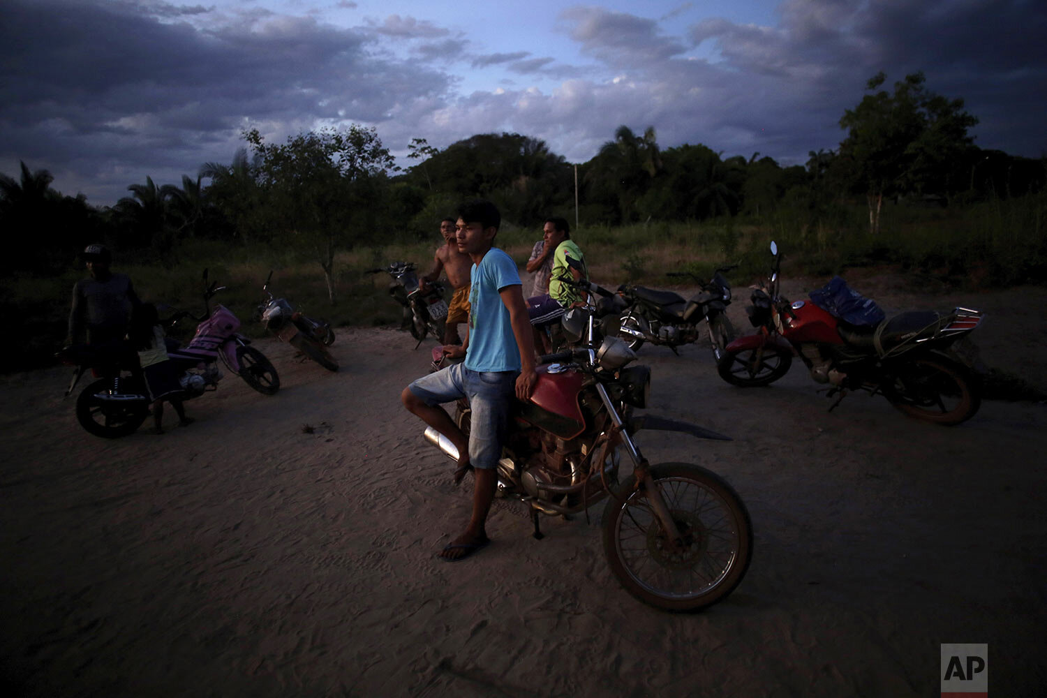  Tenetehara Indigenous men gather with their motorcycles at dusk in the Alto Rio Guama Indigenous Territory, near Paragominas, in the northern Brazilian state of Para, Monday, Sept. 7, 2020. (AP Photo/Eraldo Peres) 