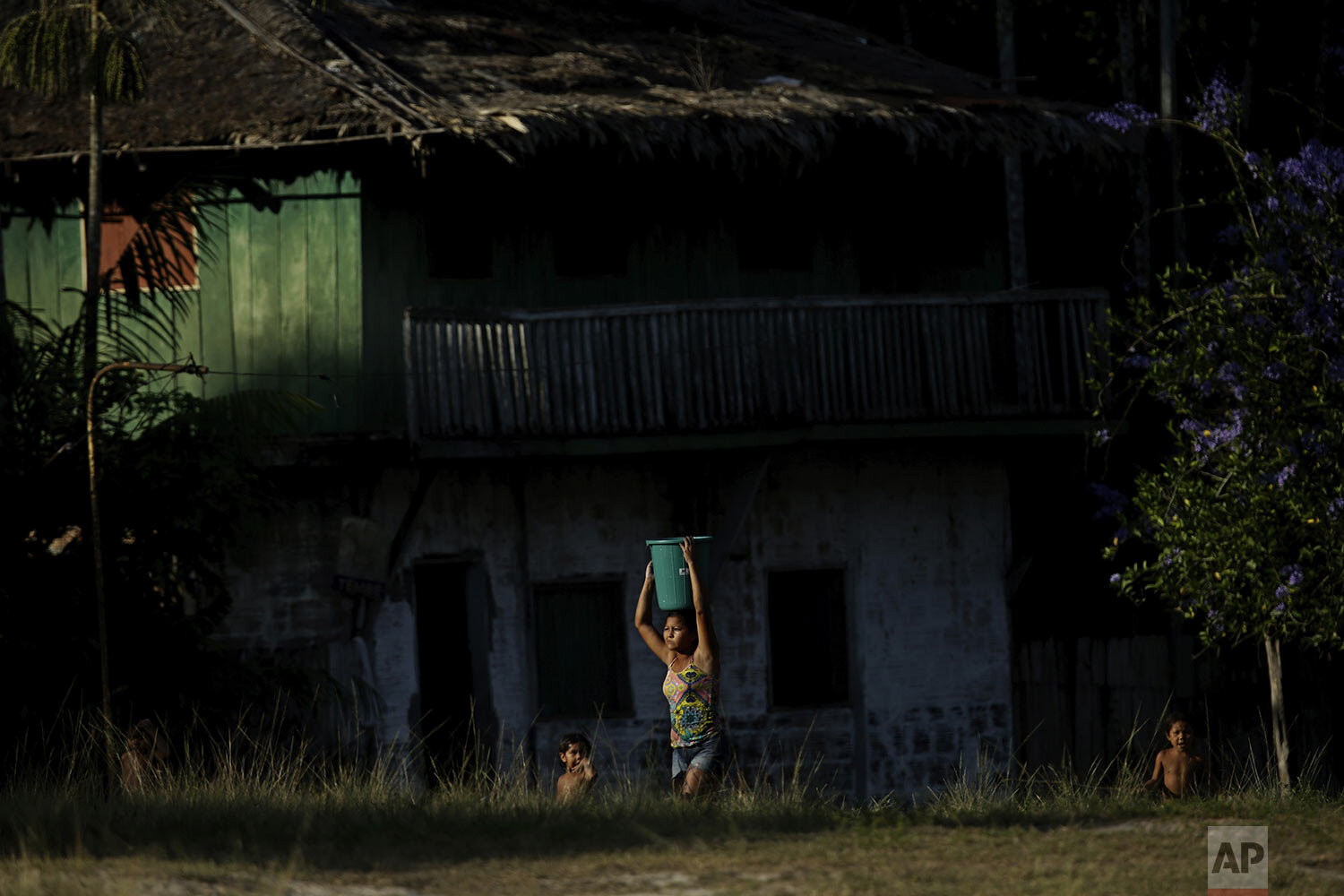  Tenetehara Indigenous Mainara Tembe carries a bucket of water atop her head followed by her children, in the Alto Rio Guama Indigenous Territory, near Paragominas, in the northern Brazilian state of Para, Monday, Sept. 7, 2020. (AP Photo/Eraldo Pere