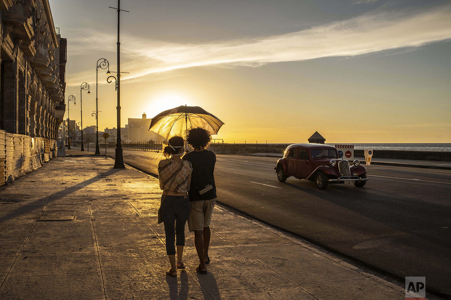  A couple wearing masks amid the new coronavirus pandemic walk on the Malecon seawall at sunset in Havana, Cuba, Aug. 31, 2020. Authorities introduced new measures for 15 days aimed at containing the spread in Havana, like a curfew from 7pm until 5am