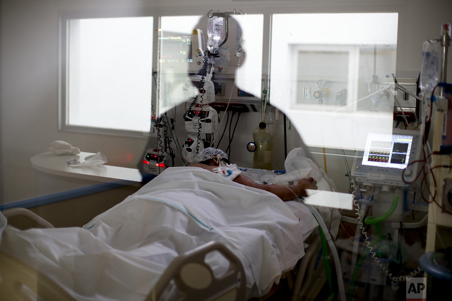  An ICU nurse is reflected in a window as he checks in on a COVID-19 patient at the El Cruce Dr. Nestor Carlos Kirchner Hospital on the outskirts of Buenos Aires, Argentina, Sept. 15, 2020. Healthcare workers warn they are being pushed beyond their l