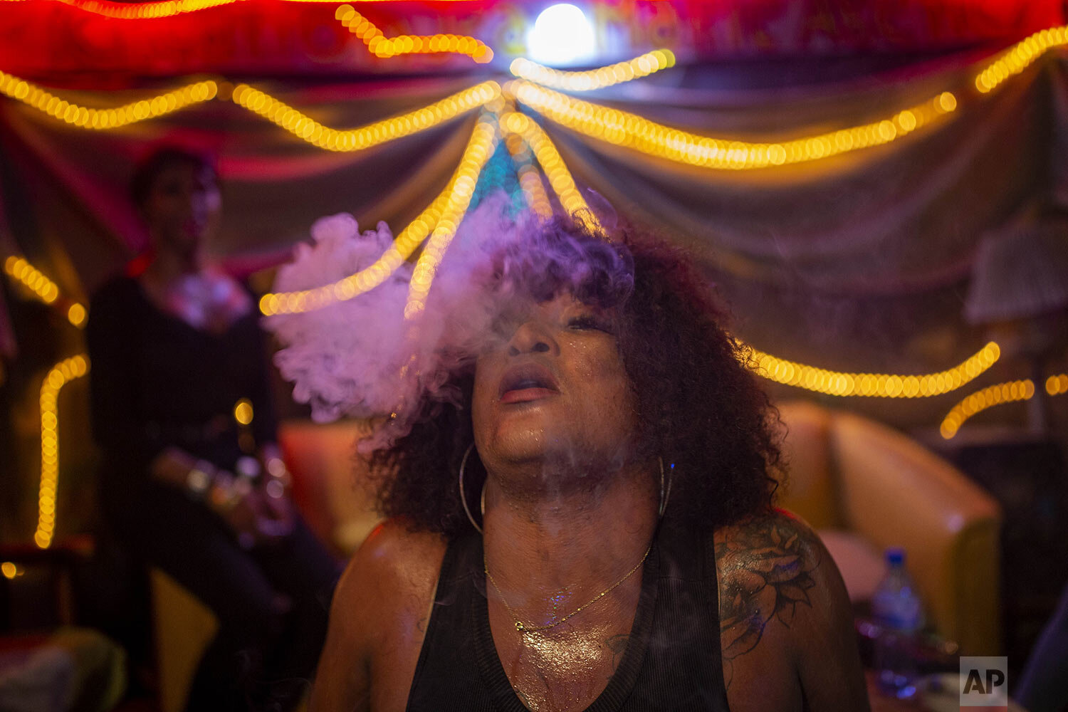  Transgender Laurent Voltus exhales cigarette smoke while dancing with friends at a club in Port-au-Prince, Haiti, Aug. 18, 2020. Voltus lives at the Kay Trans Haiti Center located in an area where residents can bring their partners, go out to clubs,