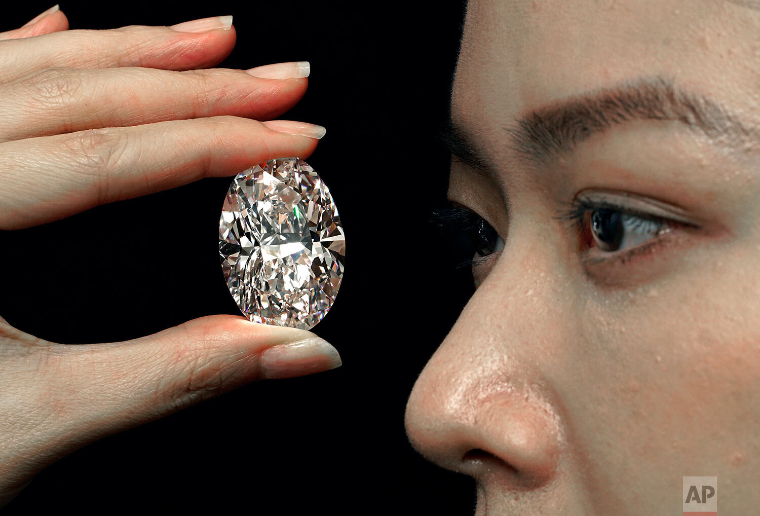  A 102.39 carat, D color, flawless diamond is displayed by a model at a Sotheby's auction room in Hong Kong Monday, Sept. 28, 2020.  (AP Photo/Vincent Yu) 