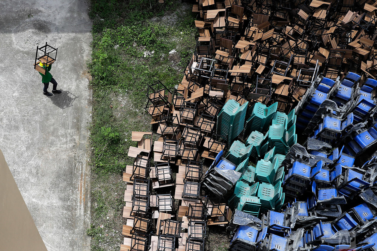  A worker arranges chairs as they temporarily convert a public school to a COVID-19 quarantine facility in Quezon city, Philippines on Tuesday, Sept. 1, 2020, as the government further eased lockdown restrictions despite the country having the most c