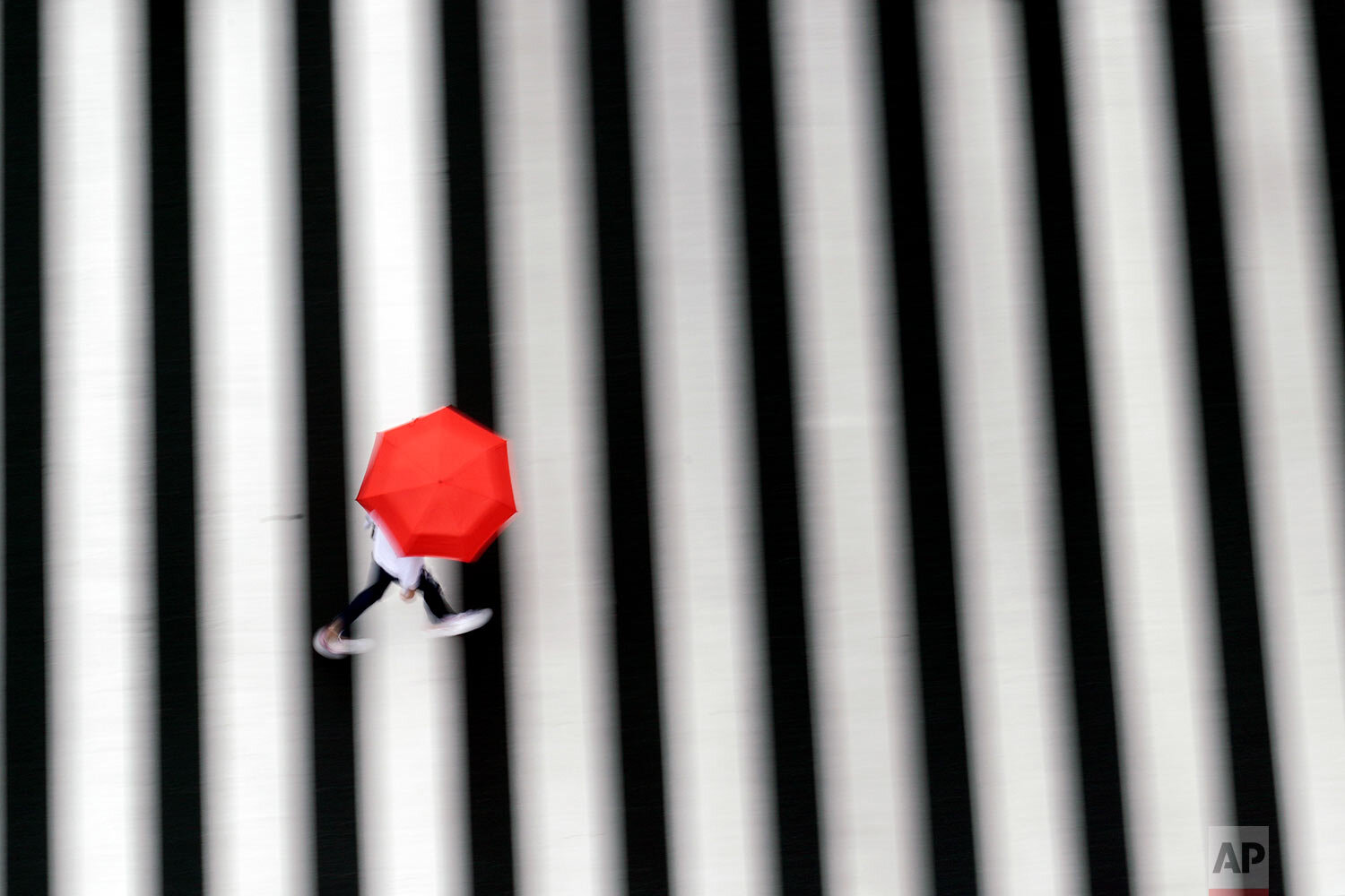  A woman walks a pedestrian crossing in the rain Wednesday, Sept. 23, 2020, in Tokyo.  (AP Photo/Eugene Hoshiko) 