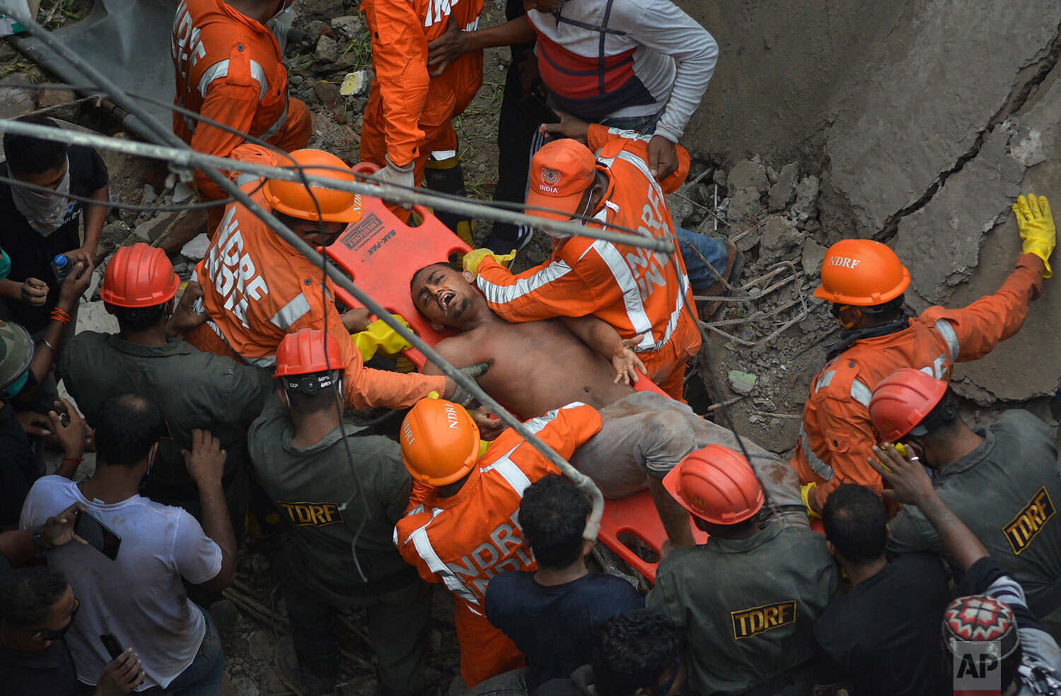  A man is rescued from the debris after a residential building collapsed in Bhiwandi in Thane district, a suburb of Mumbai, India, Monday, Sept. 21, 2020. (AP Photo/Praful Gangurde) 
