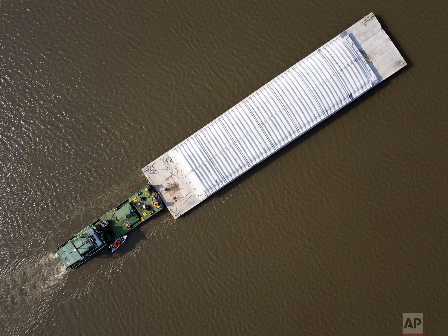  A tugboat pushes a barge carrying dry cement over the Paraguay River from Mariano Roque Alonso to Asuncion, near the Remanso Bridge in Paraguay, Wednesday, Oct. 7, 2020. (AP Photo/Jorge Saenz) 