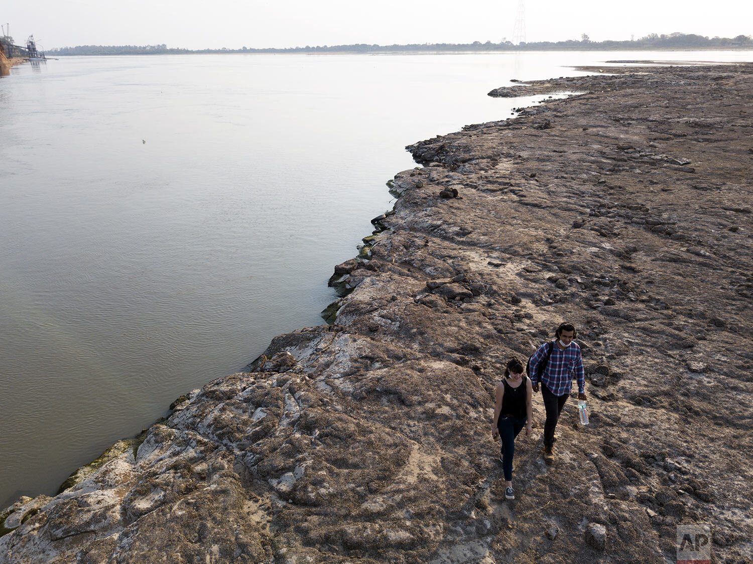  People walk on the remnants of an ancient volcano exposed in the middle of the Paraguay River, off Asuncion, Paraguay, Tuesday, Oct. 6, 2020. (AP Photo/Jorge Saenz) 
