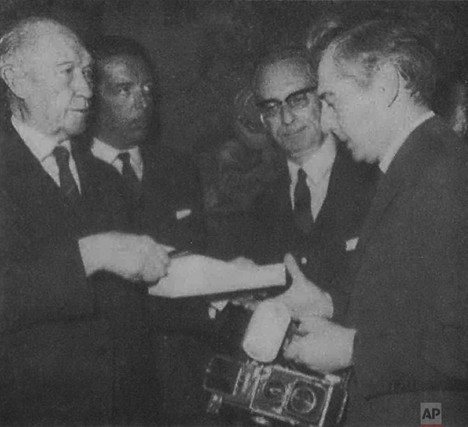  Konrad Adenauer, left, hands a signed copy of his memoirs to AP Photographer Jean-Jacques Levy, right, at the author's reception, in 1966, in Paris, France. (AP Corporate Archives) 