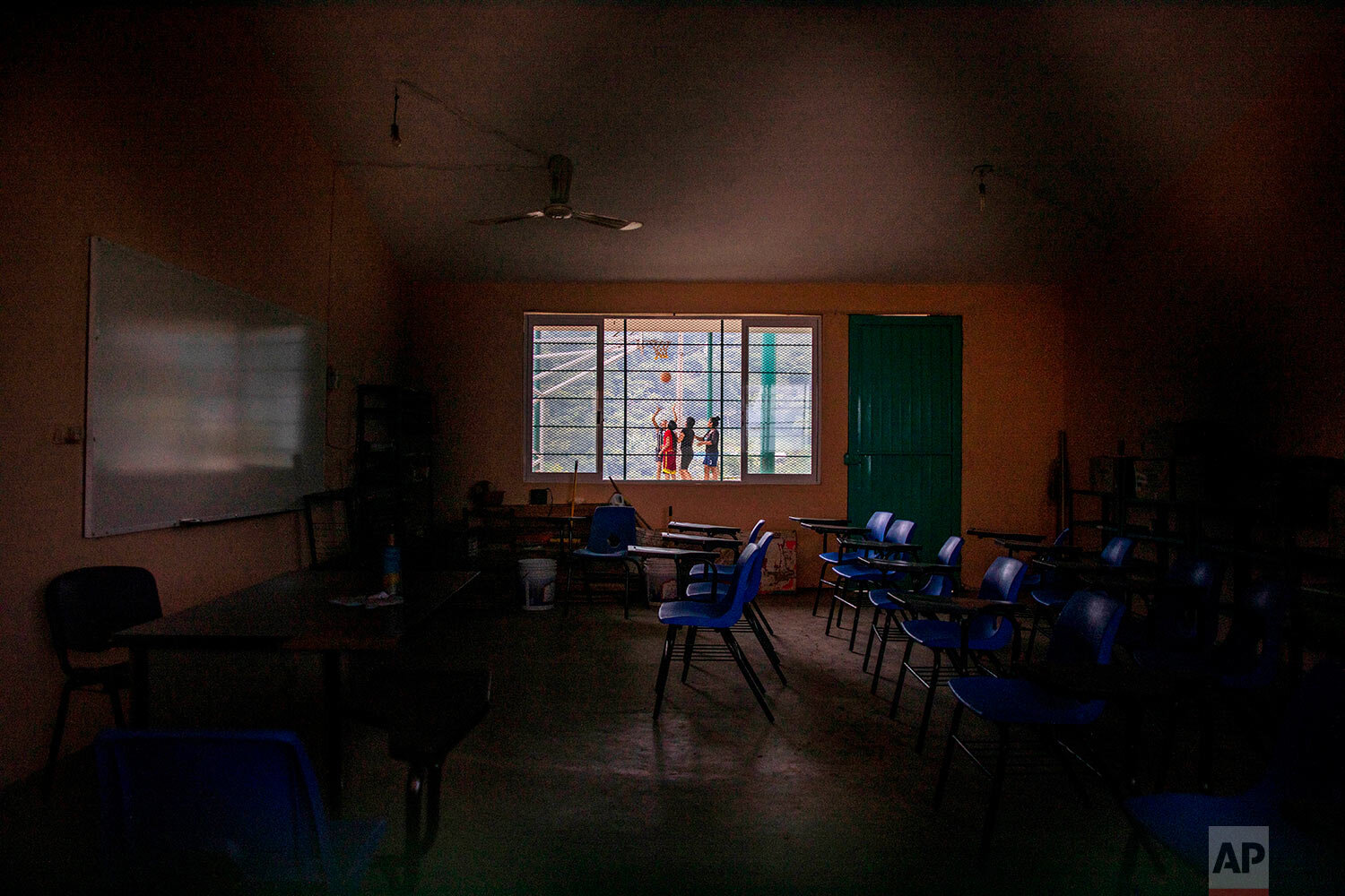  A classroom sits empty at La Ilusion community school, closed amid the COVID-19 pandemic, where girls play basketball outside in La Ilusion, Chiapas state, Mexico, Wednesday, Sept. 19, 2020. (AP Photo/Eduardo Verdugo) 