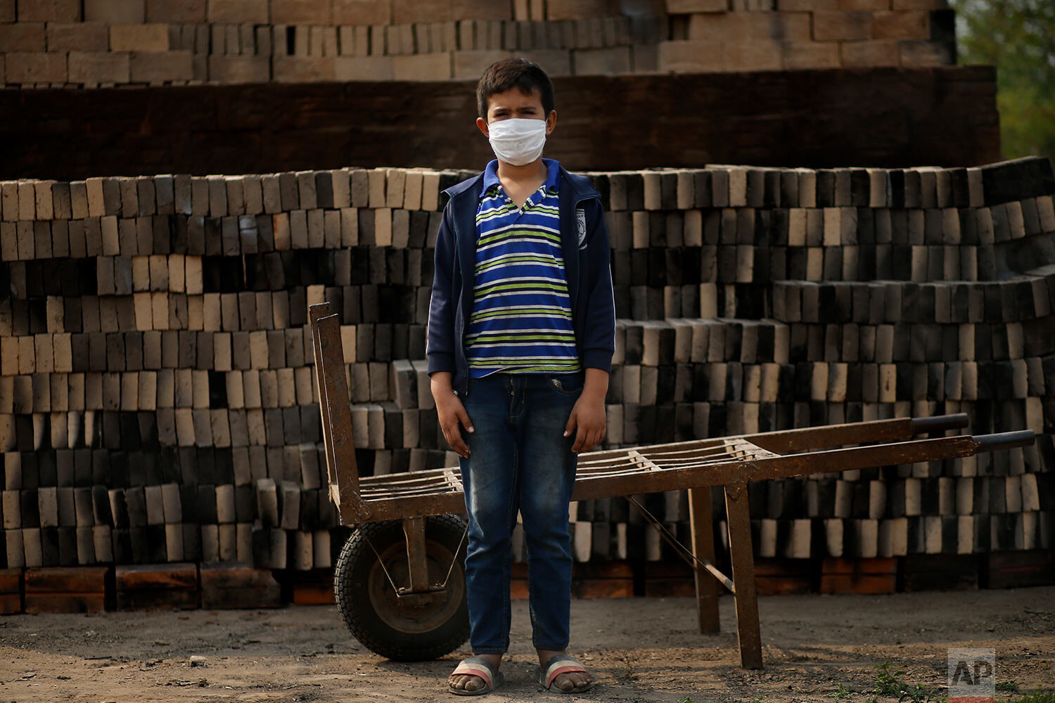 Ronnie, 10, wearing a mask to curb the spread of the new coronavirus, poses for a portrait as he works alongside his father at a small brick factory in Tobati, Paraguay, Monday, Aug. 31, 2020. (AP Photo/Jorge Saenz) 