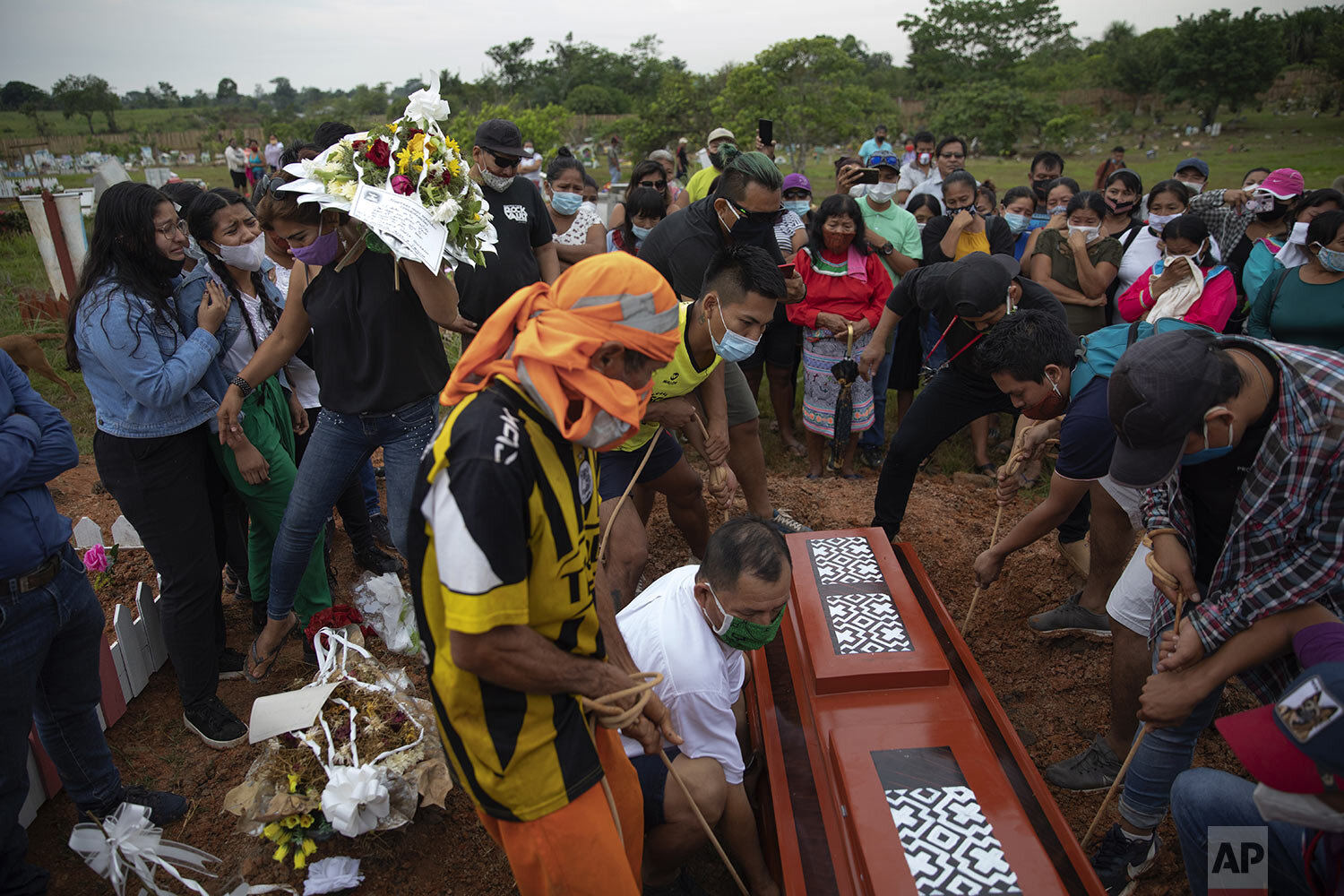  A coffin containing the remains of Jessica Soria Gonzles, a 50-year-old Shipibo Amazonian indigenous artist who died due to complications related to COVID-19, is lowered into a freshly dug grave at her graveside ceremony in Pucallpa, in Peru’s Ucay