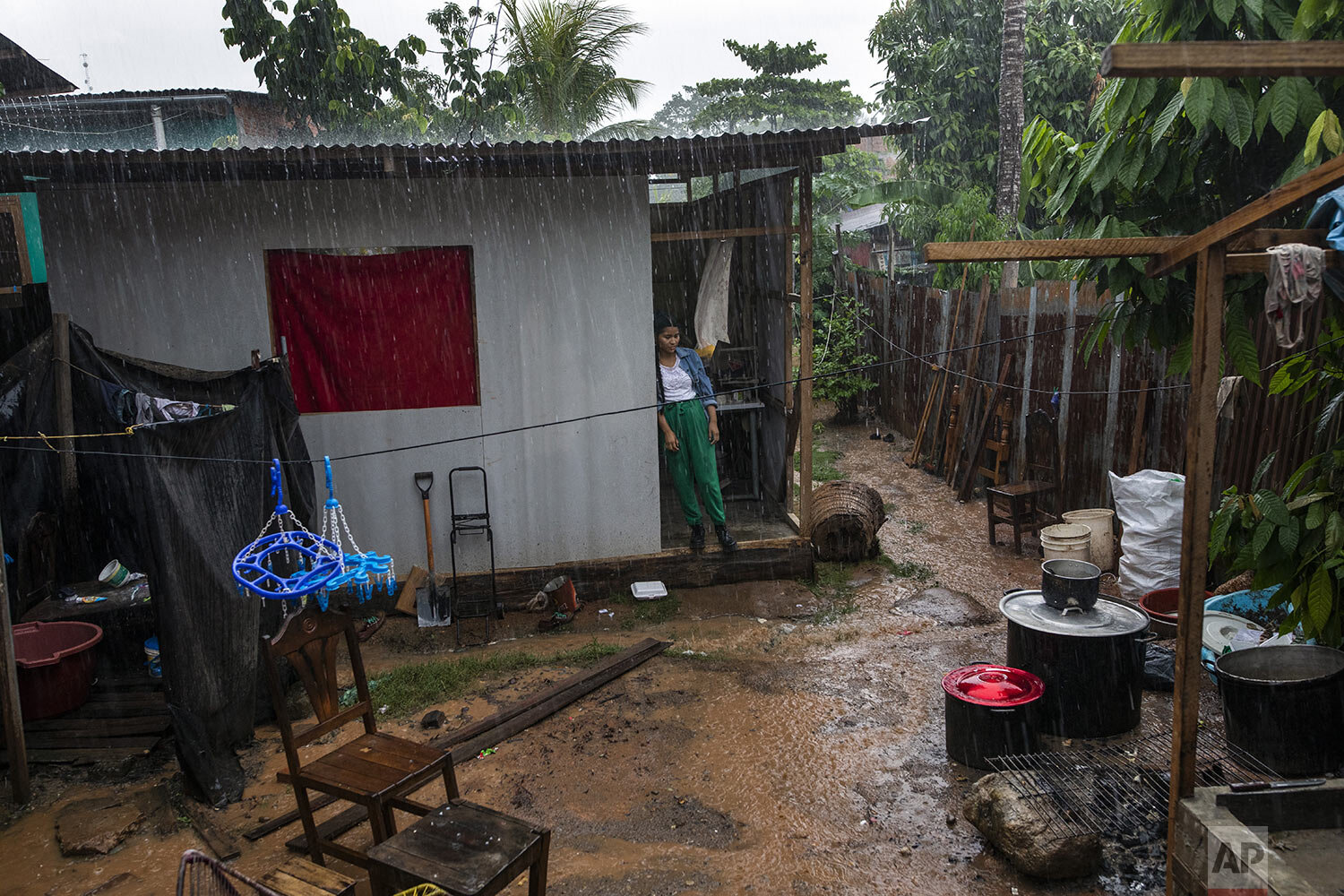  A light rain falls as 20-year-old Deyla Arce Soria stands in a doorway lamenting the death of her mother Jessica Soria Gonzales, a Shipibo Amazonian indigenous artist who died from complications related to the new cornavirus at the age of 50, in Puc