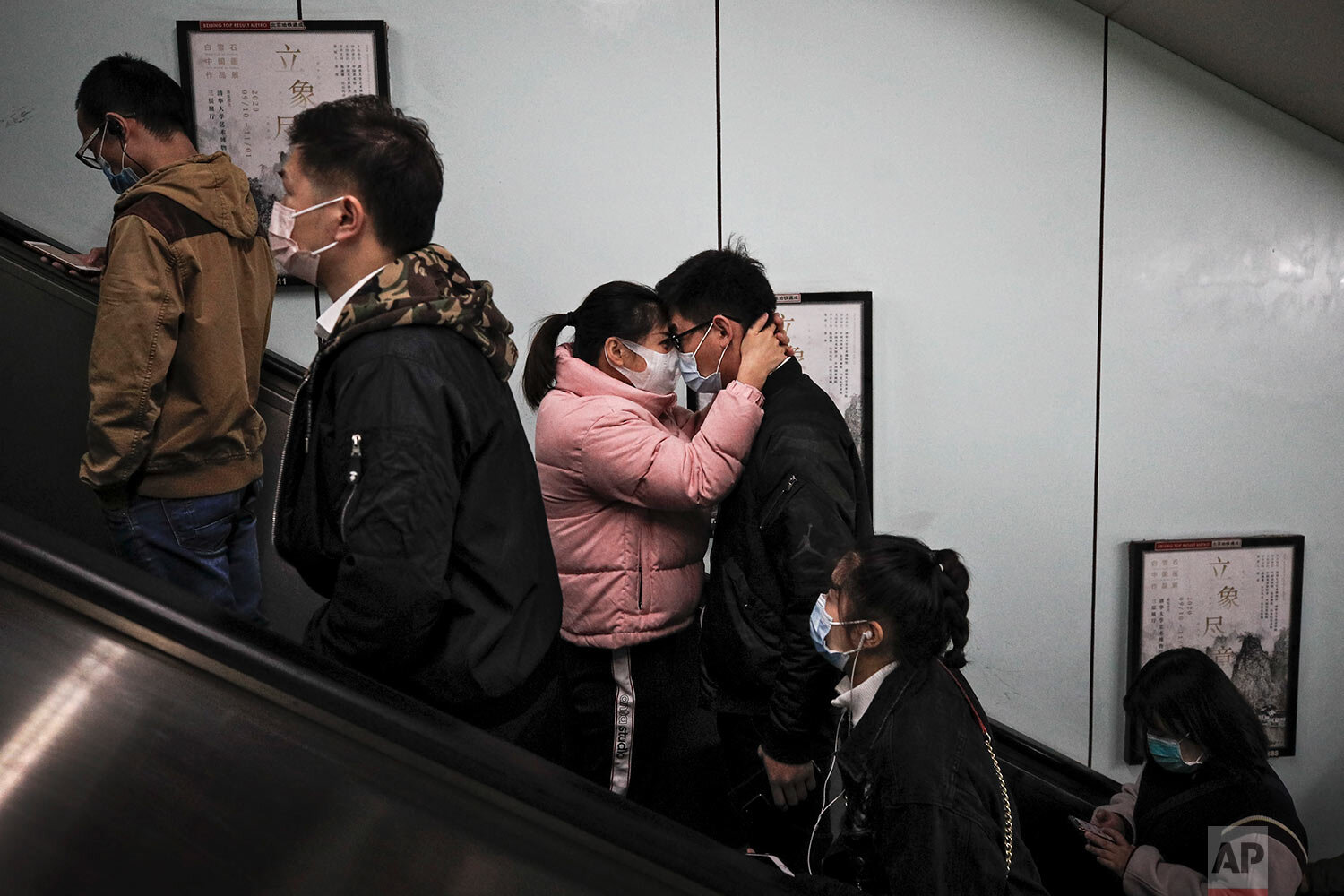  A couple wearing face masks to help curb the spread of the coronavirus embrace each other on an elevator as they exit a subway station with commuters during the morning rush hour in Beijing, Thursday, Oct. 29, 2020. (AP Photo/Andy Wong) 