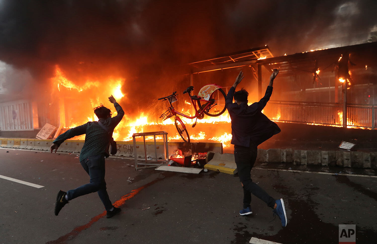  Protesters add a bicycle to a burning metro station during a rally in Jakarta, Indonesia, Thursday, Oct. 8, 2020. (AP Photo/Achmad Ibrahim) 