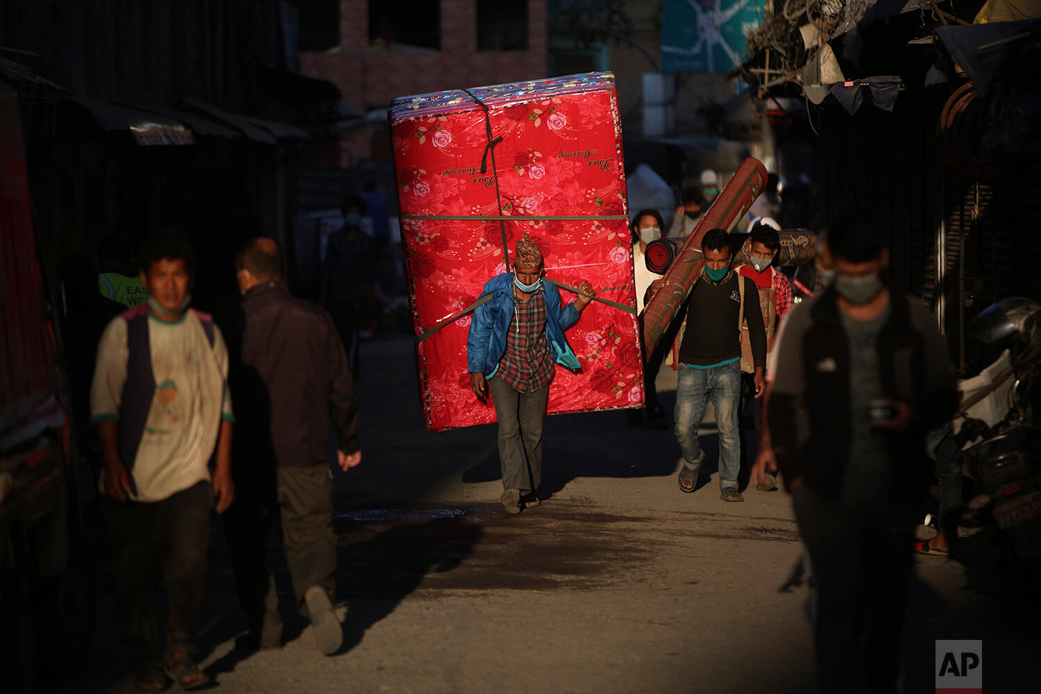  A Nepalese man wearing a mask as a precautionary measure against the coronavirus walks in a market area in Kathmandu, Nepal, Friday, Oct. 9, 2020. (AP Photo/Niranjan Shrestha) 