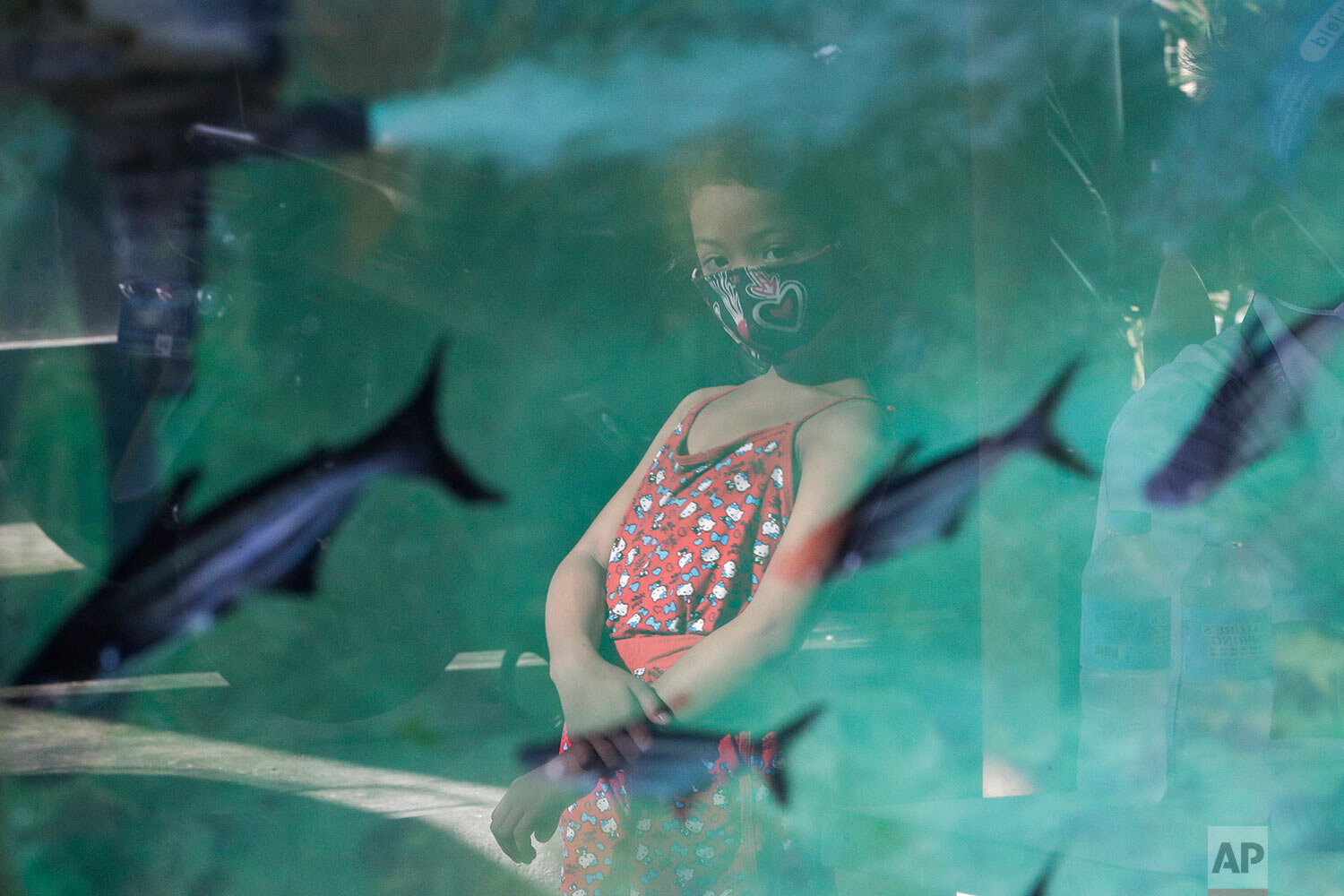  Yuna Recio, of the Philippines, wears a protective masks to prevent the spread of the new coronavirus as she looks at an aquarium at the Tandang Sora jeepney terminal in Quezon city, Philippines on Monday, Oct. 5, 2020. (AP Photo/Aaron Favila) 