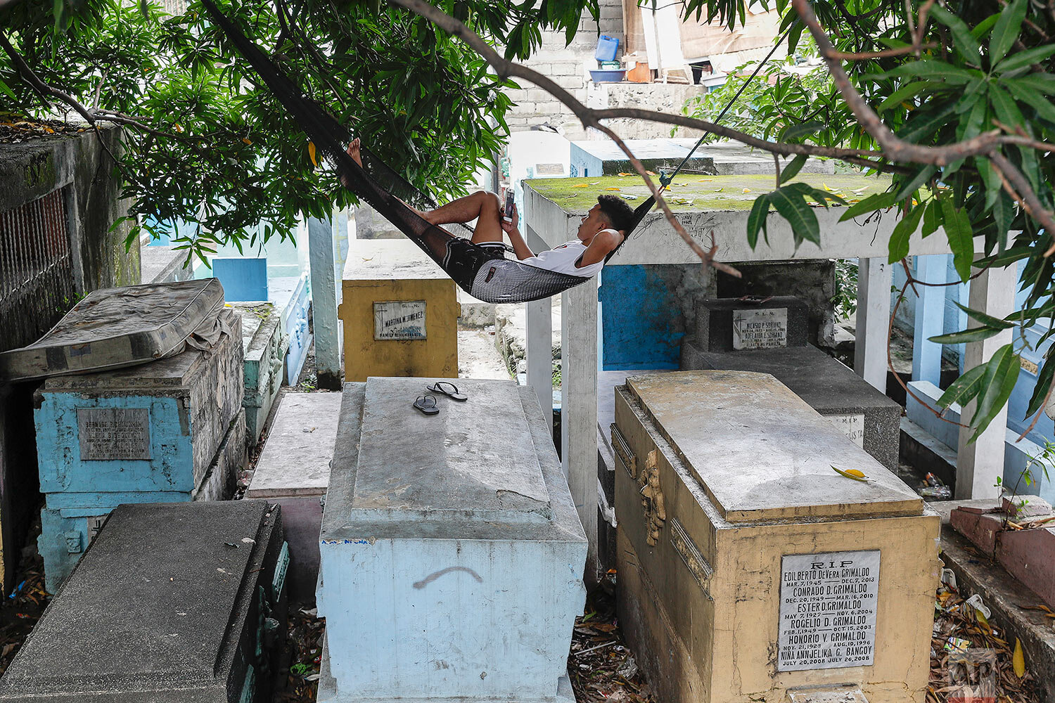  A man who lives inside the North Cemetery relaxes on his hammock on top of tombs on Wednesday, Oct. 28, 2020, in Manila, Philippines.  (AP Photo/Aaron Favila) 