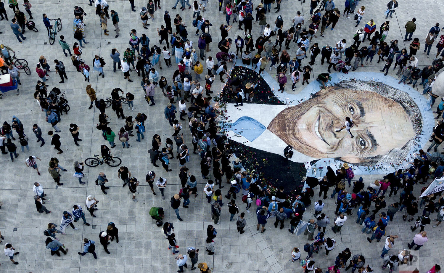  People surround a sidewalk drawing of Argentina's former President Nestor Kirchner to honor him on the 10-year anniversary of his death at Plaza de Mayo in Buenos Aires, Argentina, Oct. 27, 2020. (AP Photo/Natacha Pisarenko) 