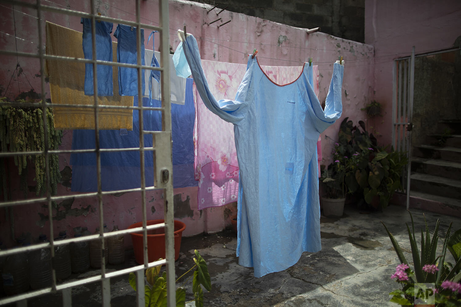  One of Elena's Suazo's two medical gowns hangs to dry at her parents' home in the Catia neighborhood of Caracas, Venezuela, Sept. 29, 2020, in between her twice-daily trips to care for her hospitalized father in the COVID-19 wing of the Jose Gregori