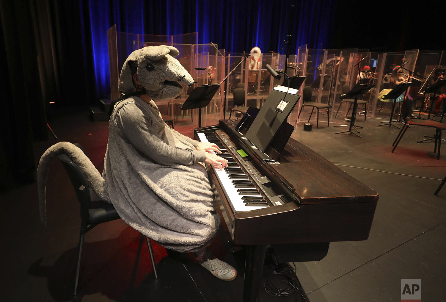  A pianist in a rat costume participates in a recorded Halloween concert by the Bogota and Youth Philharmonic Orchestras at the Colsubsidio Theater in Bogota, Colombia, Oct. 30, 2020. (AP Photo/Fernando Vergara) 