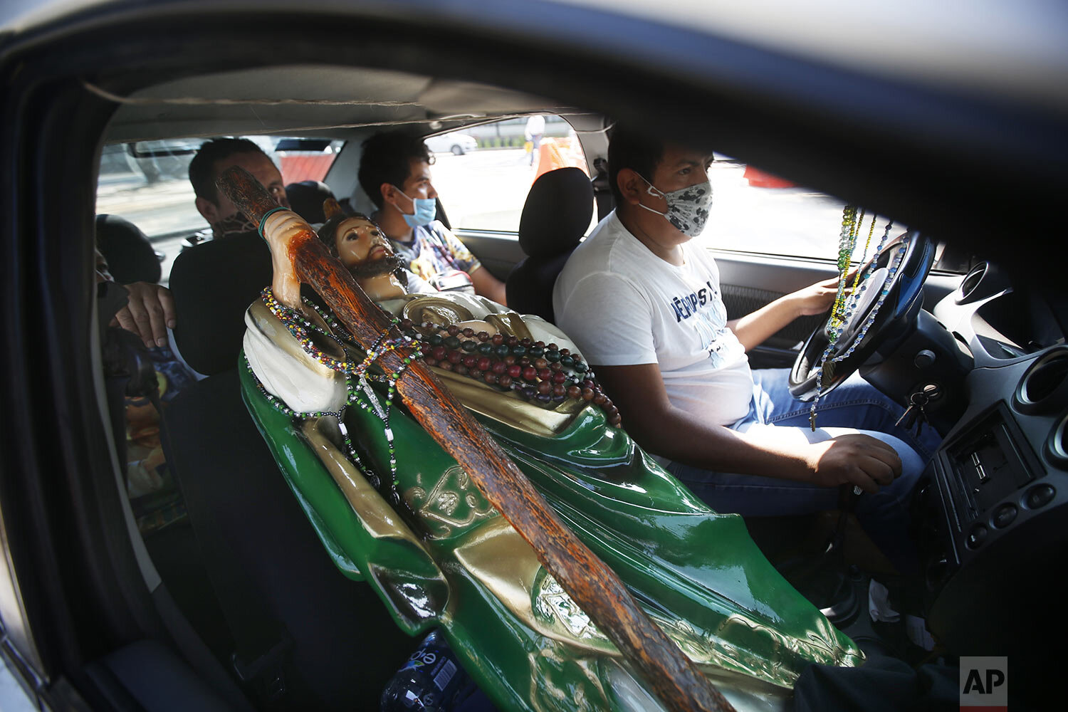 A Saint Jude statue is transported in the passenger seat of a car during the annual pilgrimage honoring Jude, the patron saint of lost causes, in Mexico City, Oct. 28, 2020. (AP Photo/Marco Ugarte) 