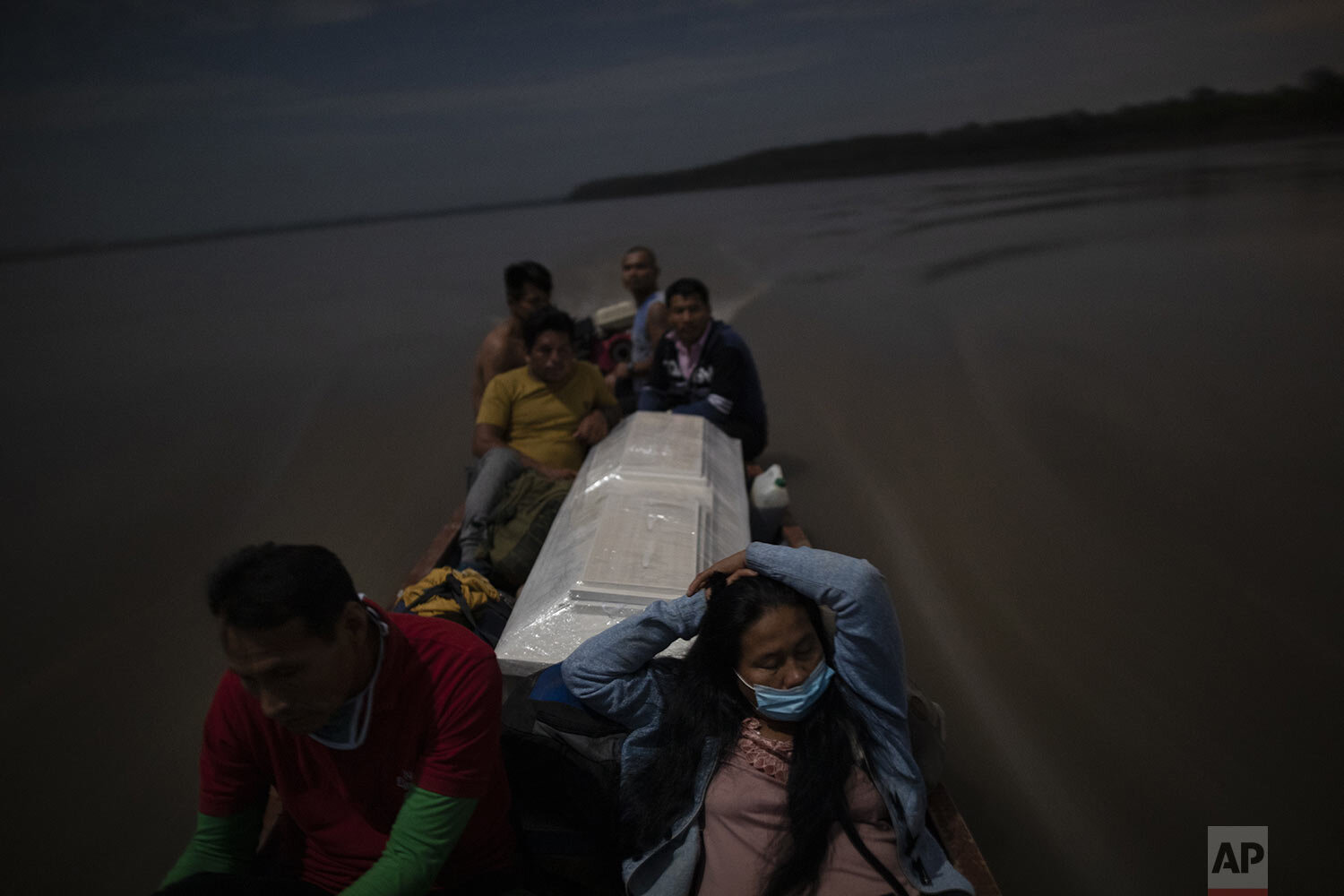  Relatives accompany the coffin that contains the remains of Jose Barbaran who is believed to have died from complications related to the new coronavirus, as they travel by boat on Peru's Ucayali River, Sept. 29, 2020. (AP Photo/Rodrigo Abd) 