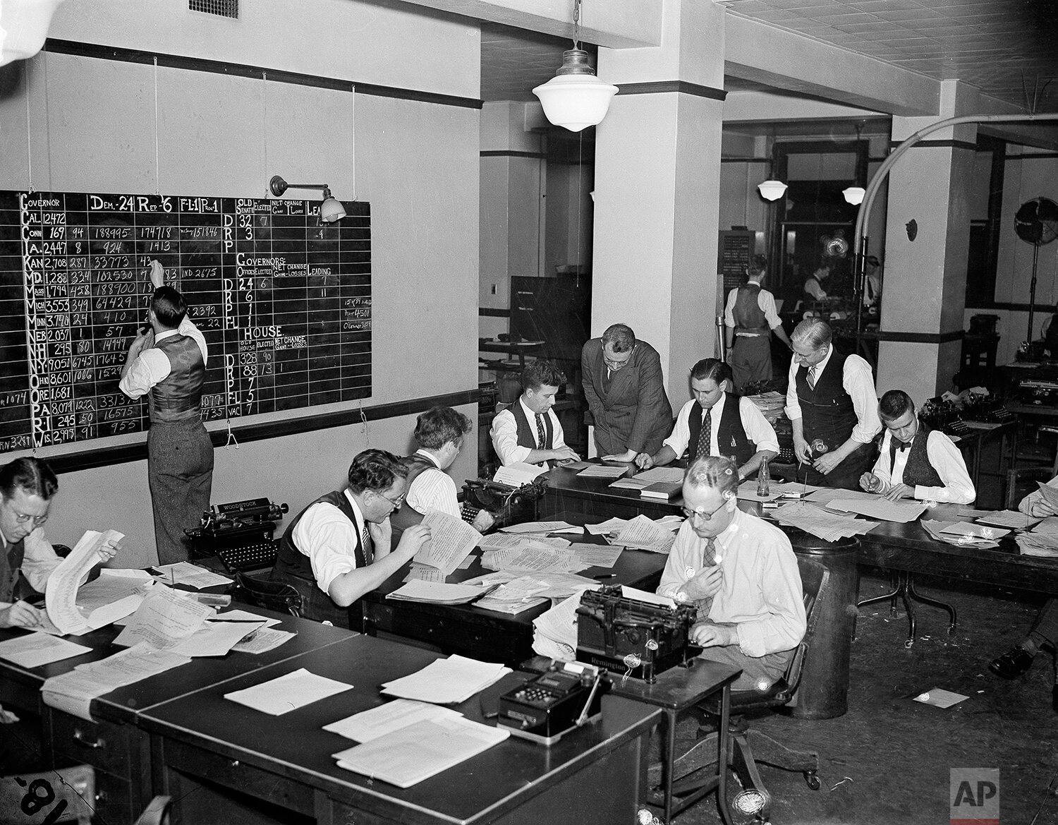 Journalists work on election night in Washington, D.C., Nov. 8, 1938. In background hunched over a writer is Milo Thompson, Washington chief of bureau, who directed the operation. (AP Photo) 