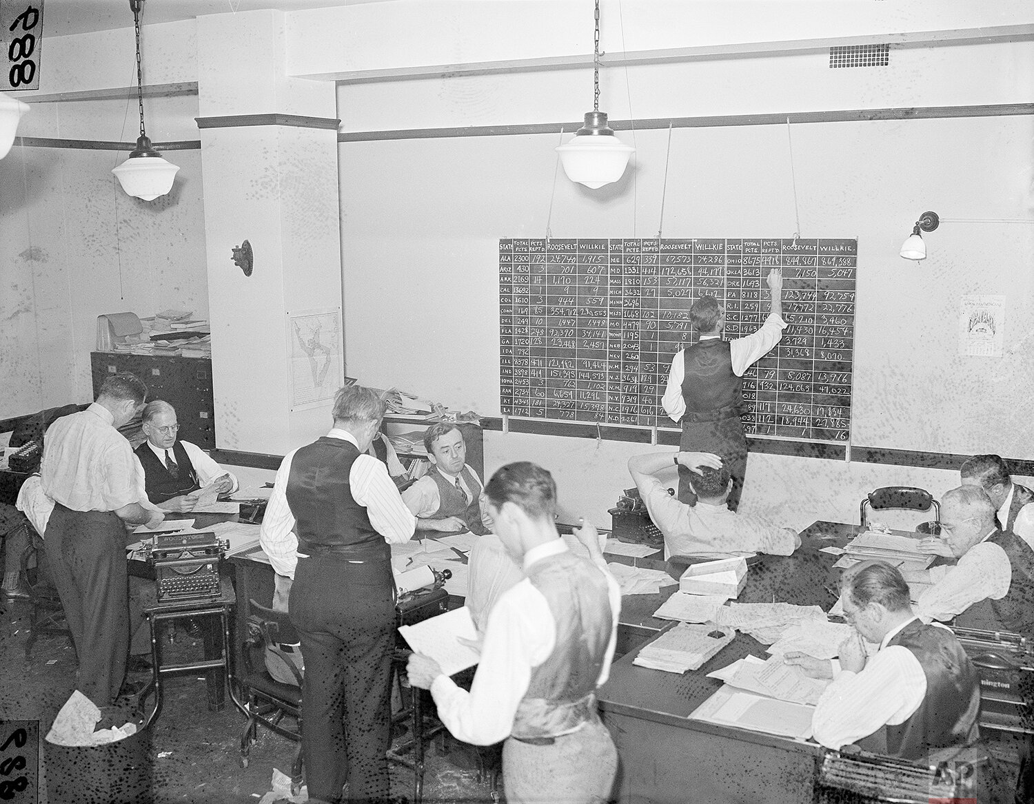  Associate Press journalists in the Washington bureau tabulate election returns, Nov. 5, 1940, keeping the score on both electoral and popular votes for the nation. The staff handled returns which flooded in over an 85,000-mile wire network. Standing