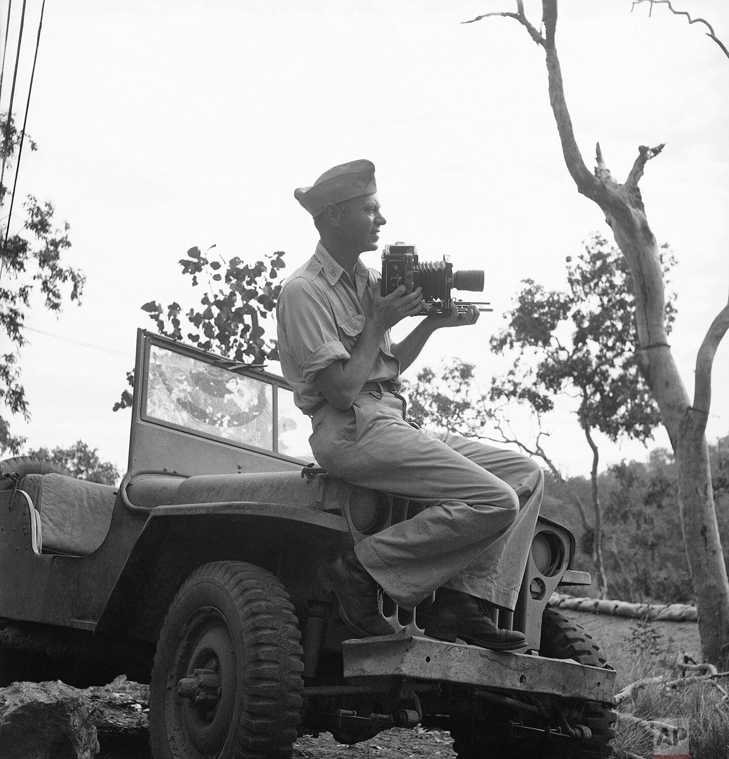  Edward Widdis, Associated Press photographer, sits on top of his “jeep” with his camera ready during the Memorial Day exercises in New Guinea on Sunday, May 30, 1943. (AP Photo) 