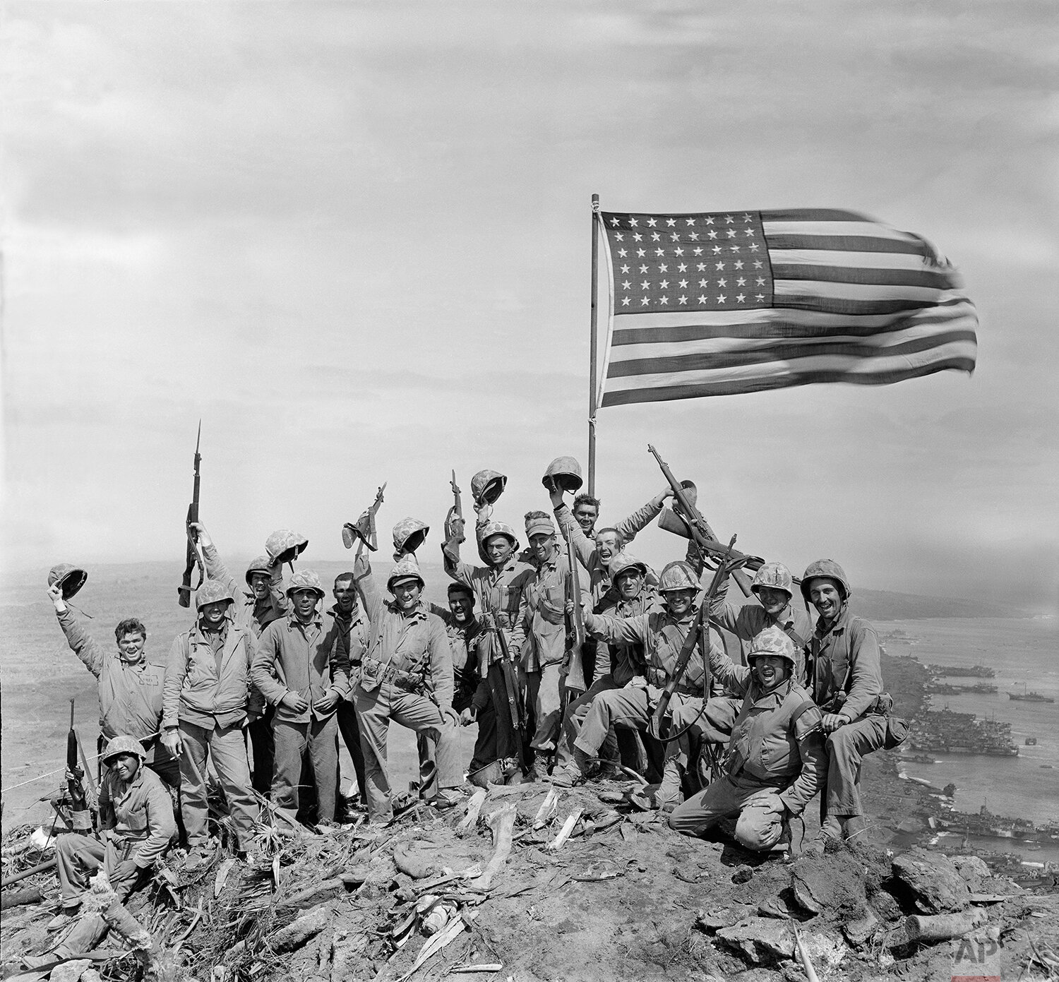  U.S. Marines of the 28th Regiment, fifth division, cheer and hold up their rifles after raising the American flag atop Mount Suribachi on Iwo Jima, a volcanic Japanese island, on Feb. 23, 1945 during World War II.  (AP Photo/Joe Rosenthal) 
