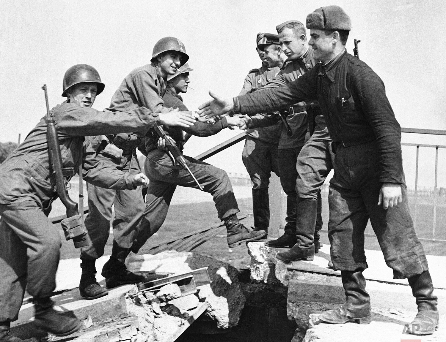  U.S. and Russian troops meet on the wrecked bridge over the Elbe River at Torgau, Germany, April 26, 1945. The Americans, left, and Russian soldiers are shown as they reach out to grasp each other's hands. The picture is part of an exhibition in Ber