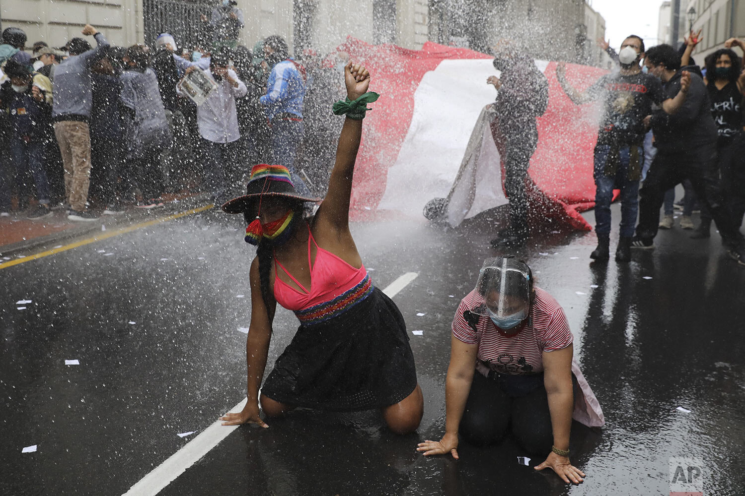  Protesters are kept back by a police water cannon as they protest lawmakers' removal of President Martin Vizcarra, near Congress in Lima, Peru, Tuesday, Nov. 10, 2020.  (AP Photo/Rodrigo Abd) 