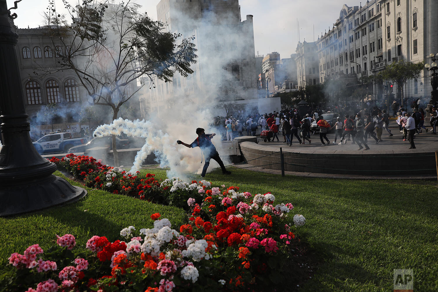  A protester throws rocks at police who launched tear gas to disperse protesters near Congress where lawmakers swore-in a new president after voting to oust President Martin Vizcarra the day before, in Lima, Peru, Tuesday, Nov. 10, 2020. (AP Photo/Ro