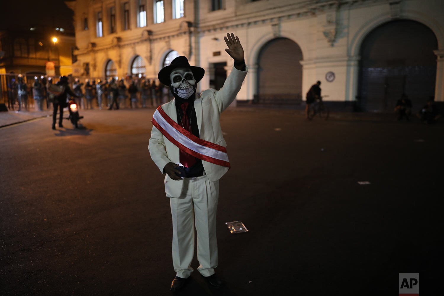 A man dressed as Peru's newly sworn-in president and wearing a mask symbolizing death waves during a protest against the removal of President Martin Vizcarra, in Plaza San Martin in Lima, Peru, Thursday, Nov. 12, 2020. (AP Photo/Rodrigo Abd) 