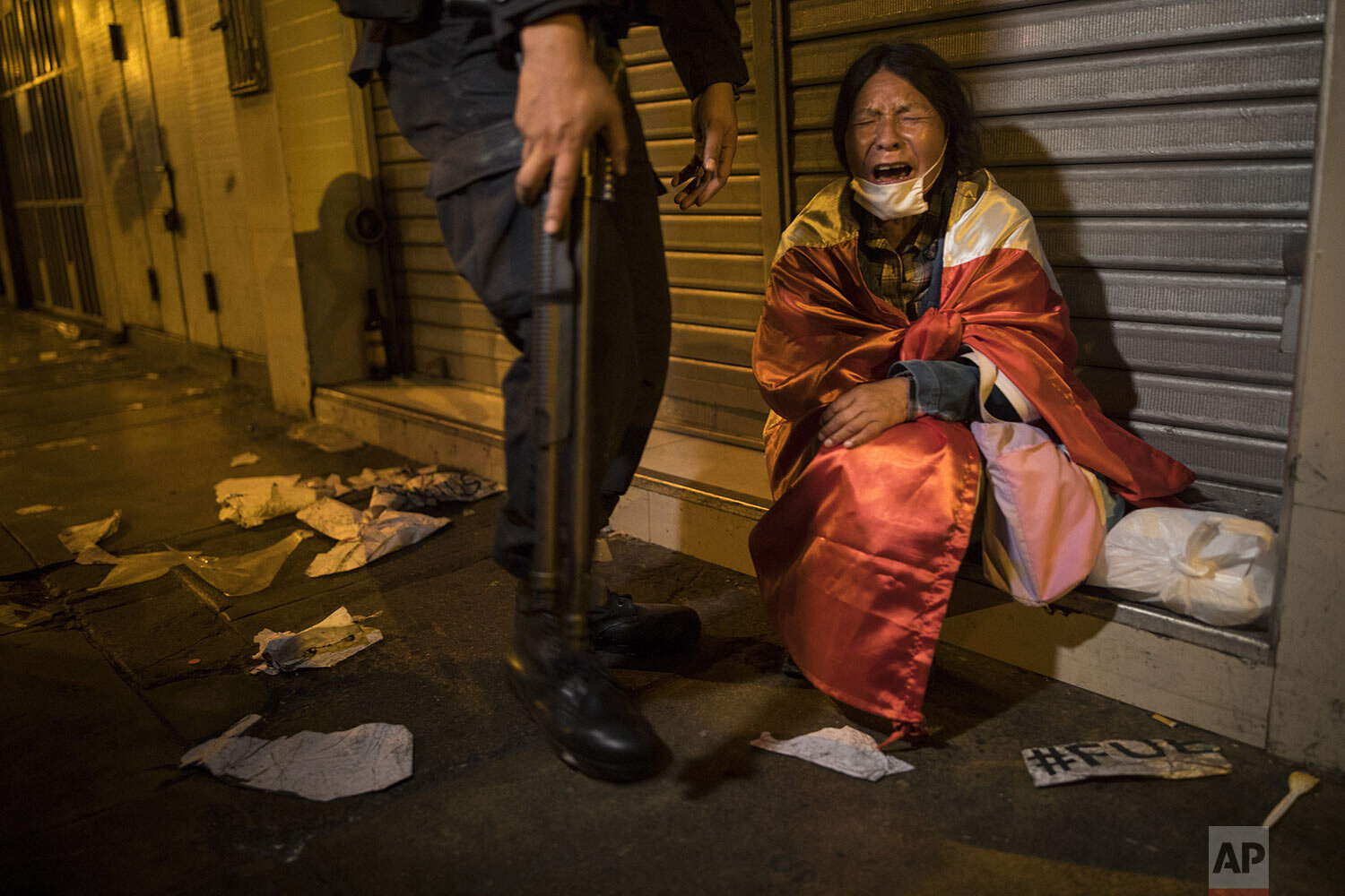  A woman wearing a Peruvian national flag cries after having swallowed tear gas launched by police on protesters who were trying to march to Congress in a demonstration against the removal of President Martin Vizcarra, in Lima, Peru, Thursday, Nov. 1