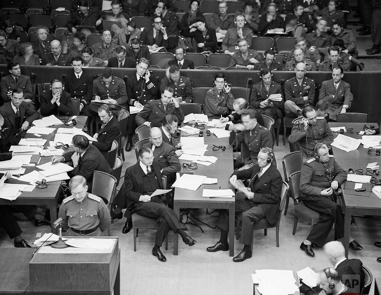  The Russian assistant prosecutor reads the indictment, (lower left) in Nuremberg, Germany on Nov. 28, 1945. The American prosecutors sit at the center table nearest the camera. Left is Justice Robert Jackson and, right, his assistant. Far, left, are