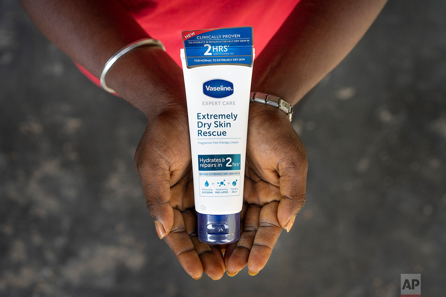  A 27-year-old woman holds a skin care product outside her house in Malaysia, on Monday, Nov. 16, 2020. She quit school at 14 and went to work on the plantation as all the women before her had done. She said she never really saw any other life for he