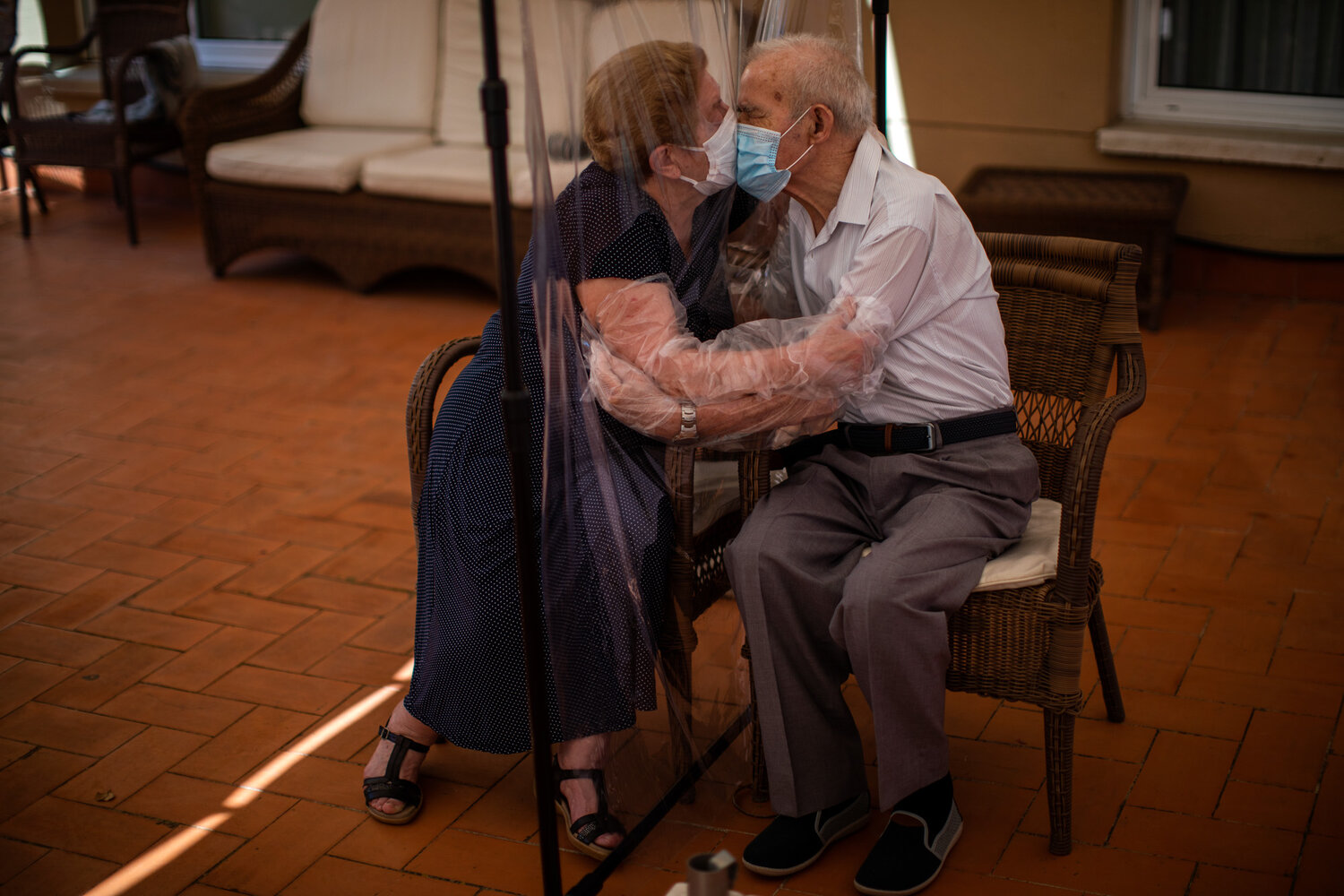 Agustina Canamero, 81, and Pascual Perez, 84, hug and kiss through a plastic film screen to avoid contracting the coronavirus at a nursing home in Barcelona, Spain, on June 22, 2020. (AP Photo/Emilio Morenatti)
