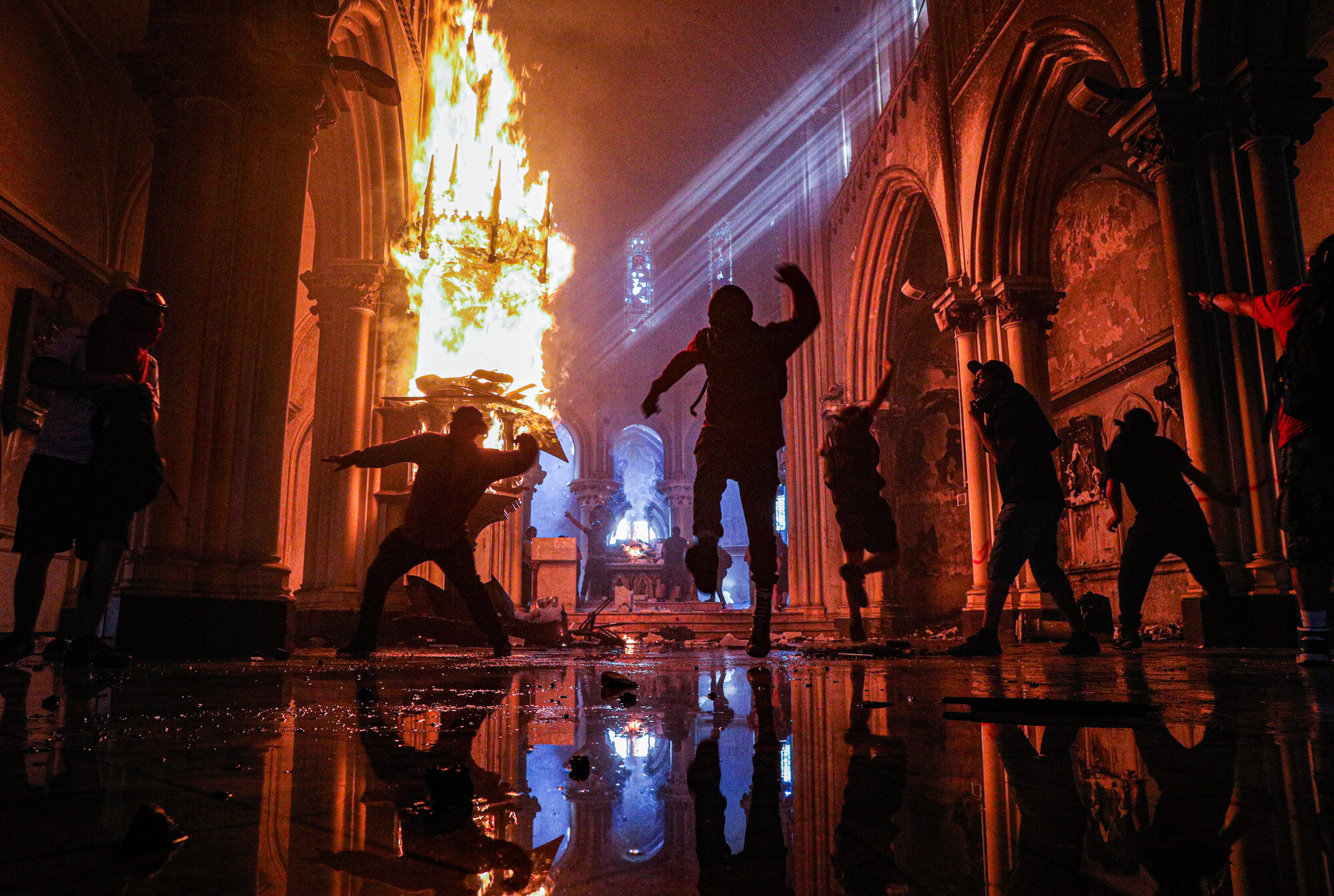 Protesters storm the San Francisco de Borja church, which belongs to the Carabineros, Chile's national police force, in Santiago, Chile, on Oct. 18, 2020, the first anniversary of the start of anti-government mass protests over inequality. (AP Photo/Esteban Felix)