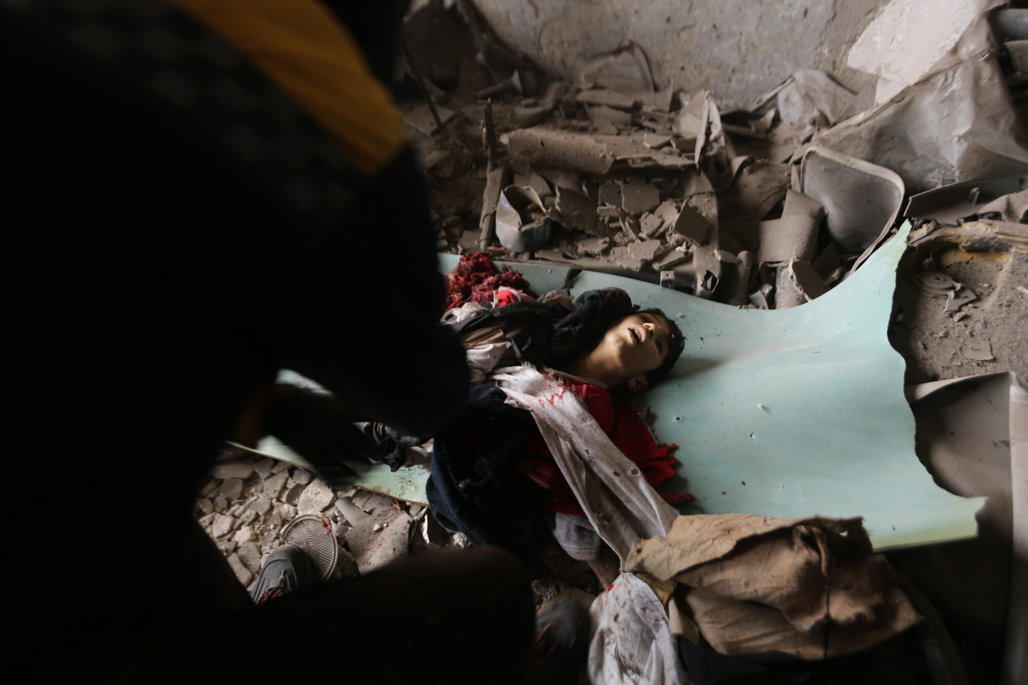 An emergency crew recovers the body of a boy killed in a government airstrike in the city of Idlib, Syria on Feb. 11, 2020. (AP Photo/Ghaith Alsayed)
