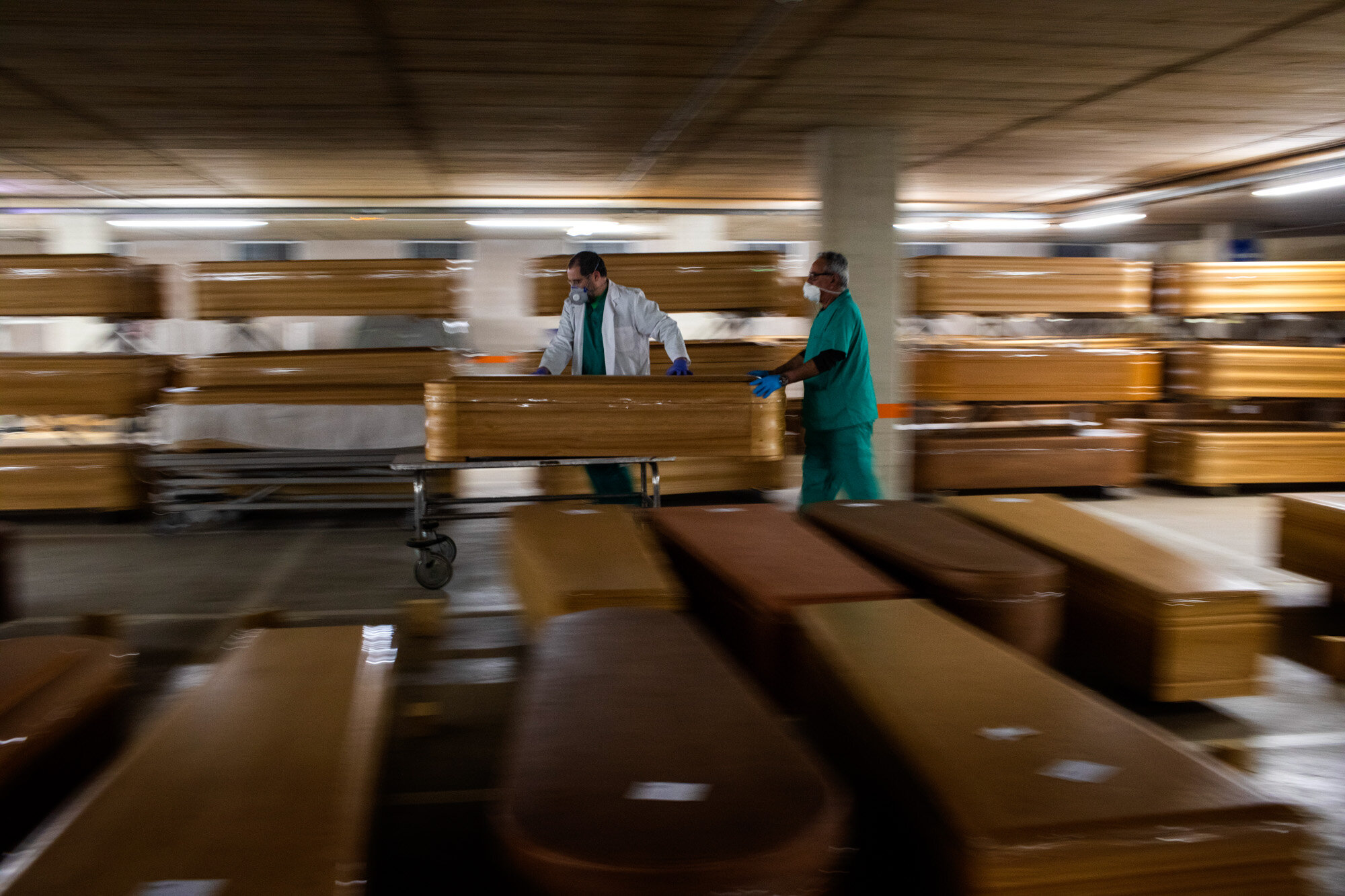  Workers move a coffin with the body of a victim of COVID-19 as other coffins are stored waiting for burial or cremation at the Collserola morgue in Barcelona, Spain, on April 2, 2020. (AP Photo/Emilio Morenatti) 